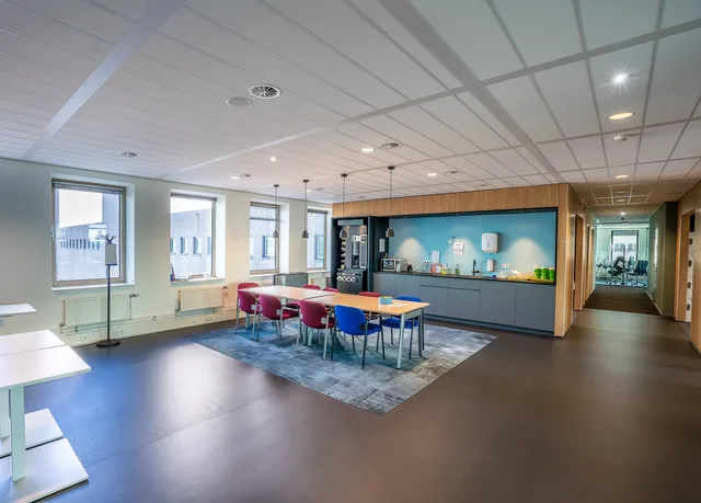 Spacious office kitchen and dining area with colorful chairs and sleek design. Tomgang og udbud: sådan læses markedsstatistik for erhvervslokaler